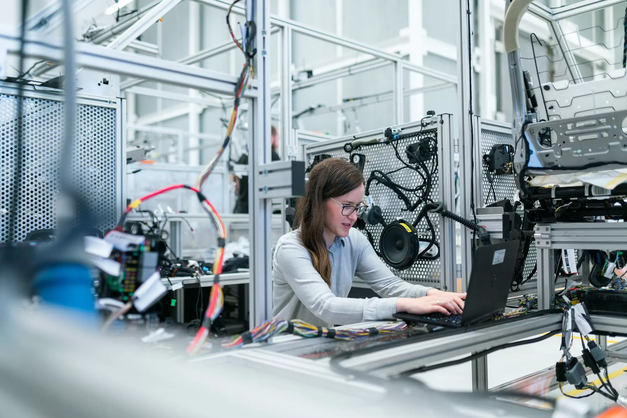 An engineer working on a laptop inside an industrial test environment.